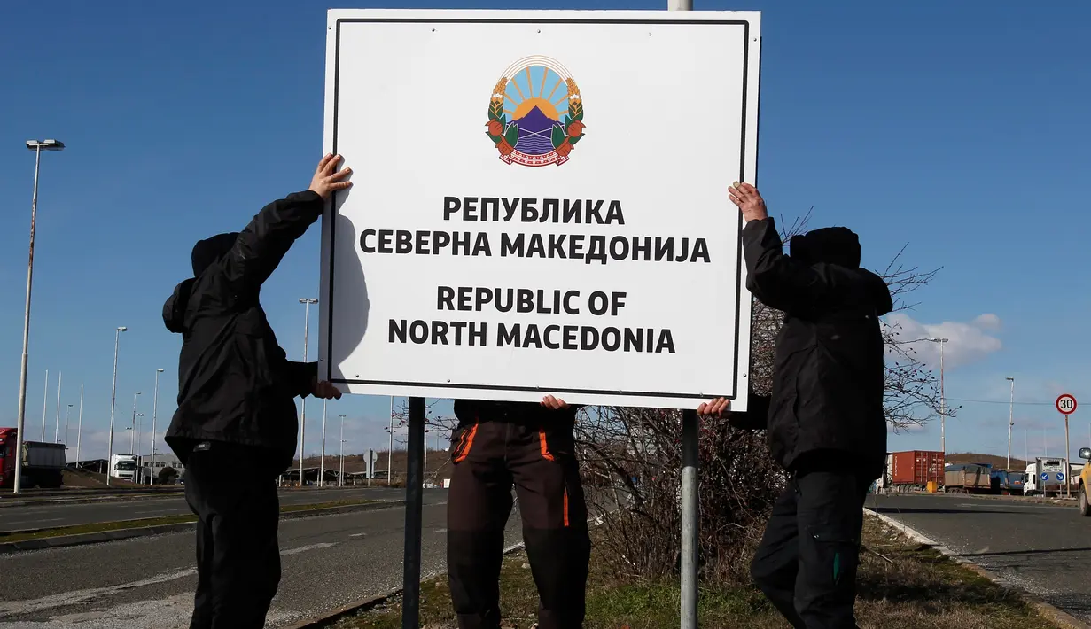 Pekerja memasang papan nama negara baru Republik Makedonia Utara di perbatasan Makedonia-Yunani, dekat Gevgelija, Rabu (13/2). Nama baru negara tersebut mulai berlaku pada 12 Februari melalui perubahan konstitusi yang diterbitkan. (AP/Boris Grdanoski)