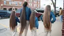 Terelynn Russel (43) dengan ketiga putrinya saat berjalan-jalan di Illinois, Amerika Serikat. Seumur hidupnya, Tere tidak pernah sekalipun menggunting rambutnya yang kini sudah hampir menyentuh tumit dengan panjang 1,87 meter. (dailymail.co.uk)