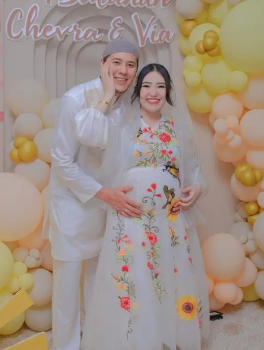 Via Vallen tampil mengenakan dress lengan panjang putih dengan aksen bordiran bunga-bunga. Dipadukan kerudung organzanya di atas rambut panjang diikat dengan poni belah dua. [@viavallen]