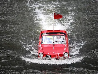 Sebuah mobil amphibi asyik berenang di sungai Mosel, Jerman dalam acara reli "Amphib 2014" (AFP PHOTO/Fredrik VON Erichse)
