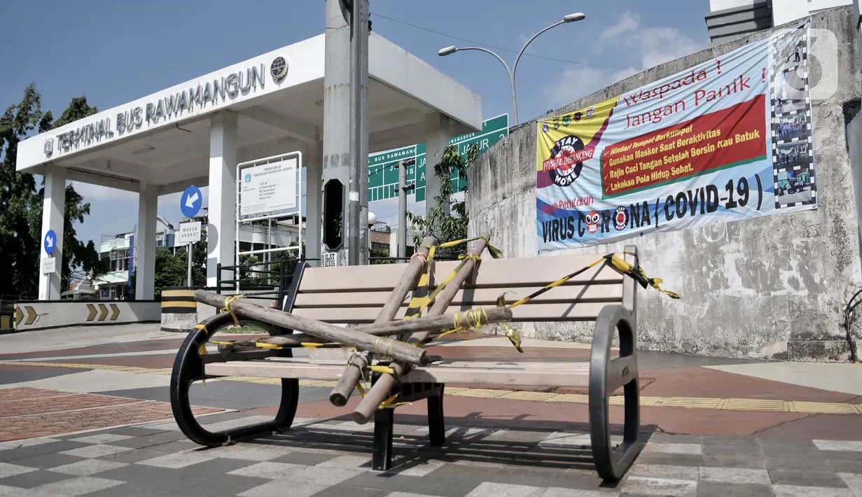 Kondisi bangku trotoar yang disegel garis pembatas dan ditutupi bambu di kawasan Rawamangun  Jakarta, Minggu (3/5/2020). Bangku trotoar di sepanjang jalan Rawamangun disegel untuk mencegah kerumunan warga sebagai upaya memutus rantai penyebaran COVID-19. (merdeka.com/Iqbal S. Nugroho)