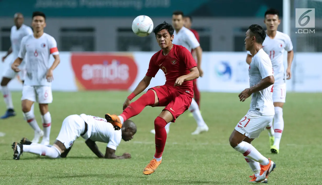 Pemain tengah Timnas Indonesia, Septian David Maulana (tengah) mencoba melewati adangan pemain Hong Kong pada laga uji coba internasional di Stadion Wibawa Mukti, Cikarang, Selasa (16/10). Laga berakhir imbang 1-1. (Liputan6.com/Helmi Fithriansyah)