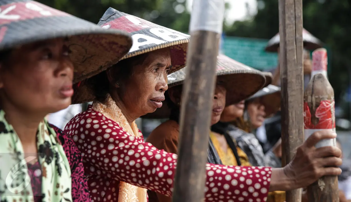Sejumlah petani Pegunungan Kendeng menabuh lesung saat menggelar aksi di depan Istana Merdeka, Jakarta, Rabu (12/4). Mereka meminta Pemerintah untuk menghentikan pembangunan dan pabrik semen di Pegunungan Kendeng. (Liputan6.com/Faizal Fanani)