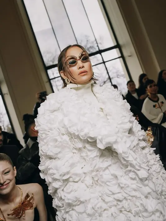 Penampilannya dipermanis dengan aksesori belt warna ivory, kacamata warna emas bentuk mata dan alis emas yang nyentrik. [@jlo]