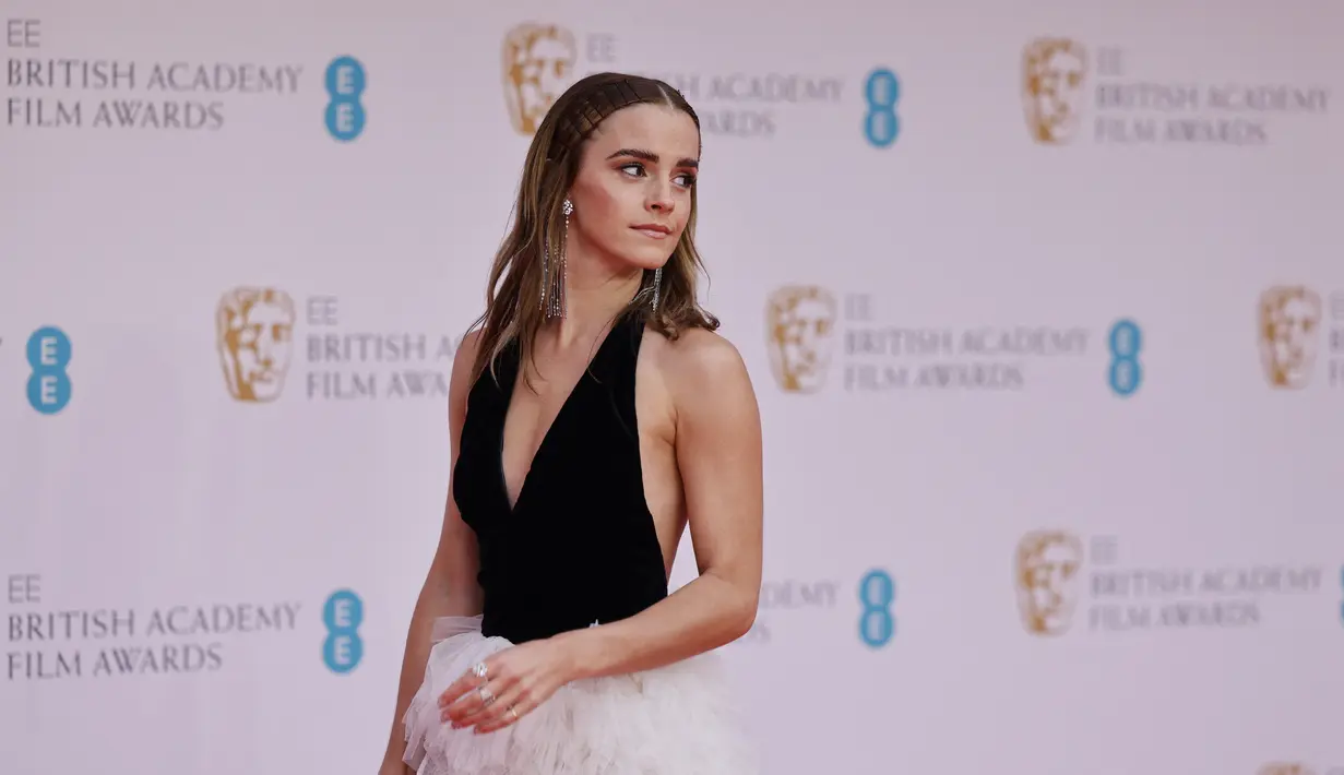 Aktris Inggris Emma Watson berpose di karpet merah saat tiba di BAFTA British Academy Film Awards di Royal Albert Hall, di London (13/3/2022). Bintang film Harry Potter ini mengenakan sepasang sepatu hak hitam runcing yang dihiasi dengan tali pergelangan kaki manik-manik. (AFP/Tolga Akmen)