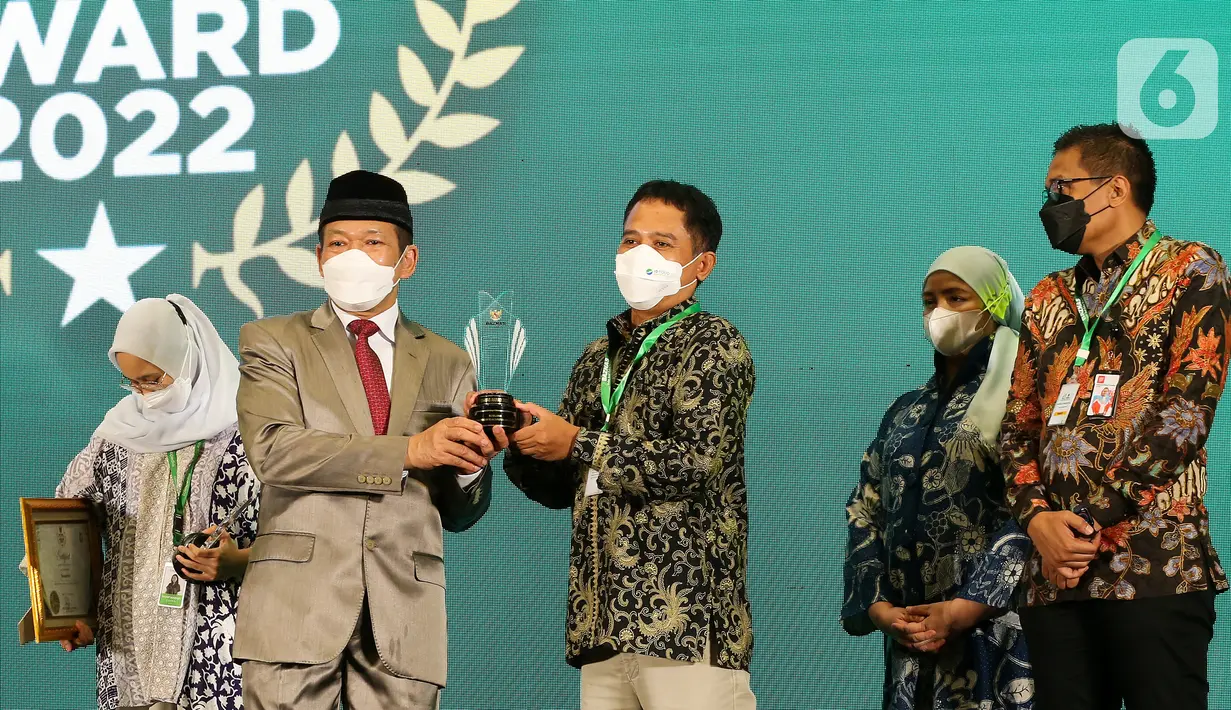 Ketua BAZNAS RI, Prof. Dr. KH. Noor Achmad memberikan penghargaan kepada Head of Government Relations & External Affairs Bukalapak, Herry Cahyono untuk kategori Mitra Pengumpulan Zakat via Financial Technology Terbaik. di Jakarta, Senin (17/01/2022). (Liputan6.com/Fery Pradolo)