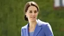 Kate Middleton saat akan menemui Kanselir Jerman,  Angela Merkel dalam tur keluarga kerajaan Inggris di Berlin, Rabu (19/7). Kate Middleton terlihat anggun dalam balutan coat dress Catherine Walker warna biru royal. (Odd ANDERSEN / AFP)