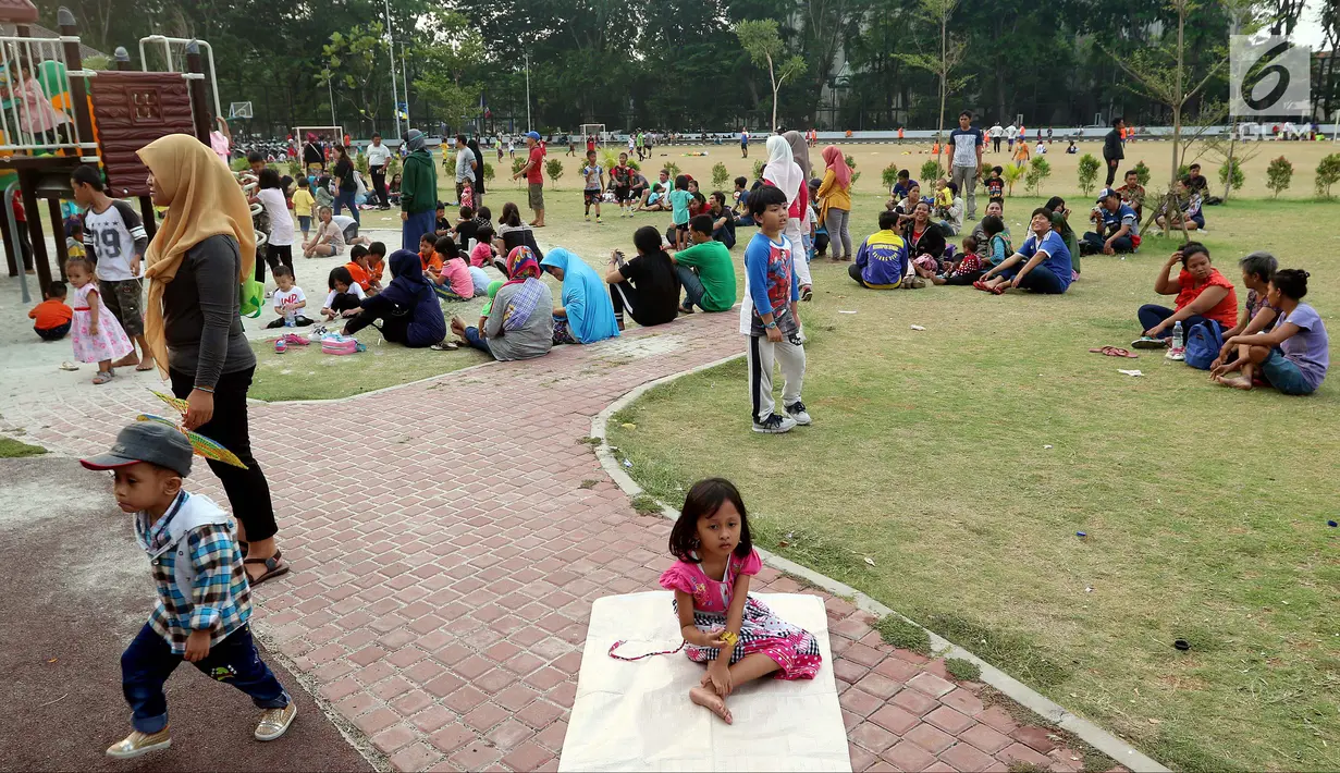 Pemandangan saat warga membawa anak-anaknya bermain di Lapangan Banteng, Jakarta, Minggu (14/10). Lapangan Banteng semakin ramai dikunjungi pada hari Minggu. (Liputan6.com/JohanTallo)