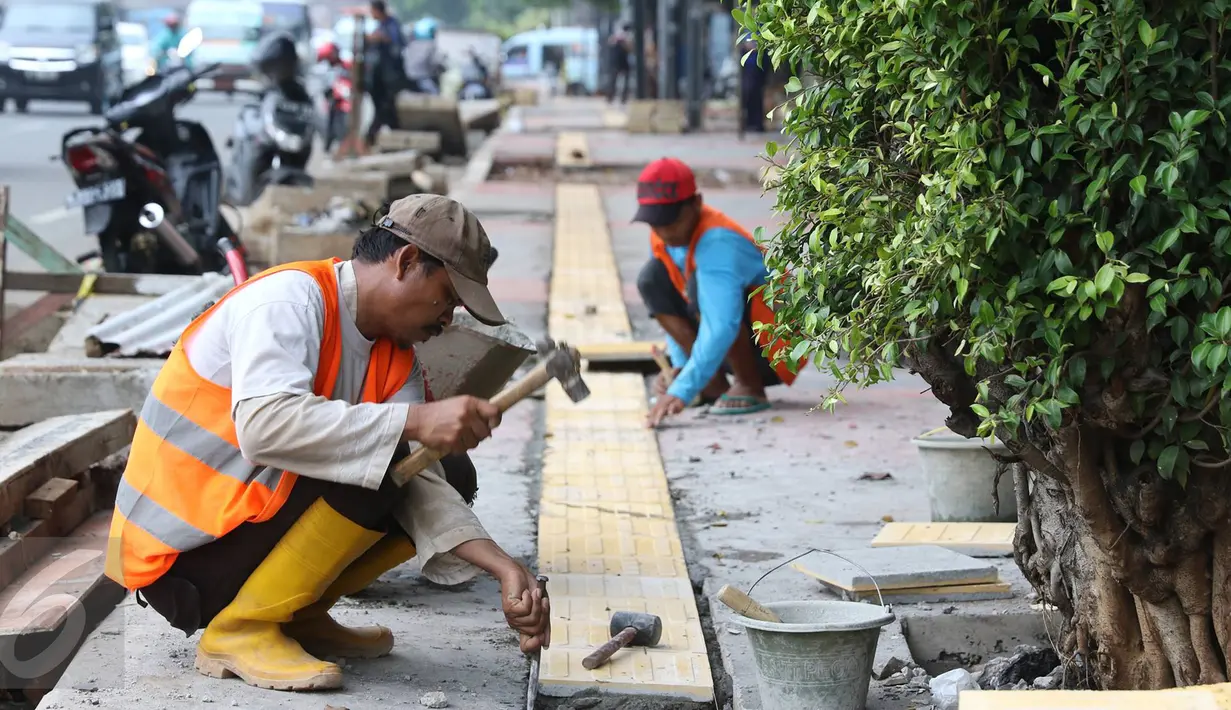 Para pekerja menyelesaikan penataan trotoar di kawasan Matraman, Jakarta, Rabu (9/11). Dinas Bina Marga DKI menyatakan penataan 39 titik trotoar telah mencapai 70 persen dan ditargetkan selesai pertengahan Desember 2016. (Liputan6.com/Immanuel Antonius)