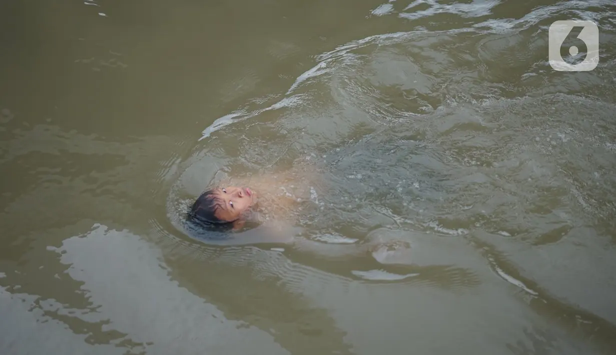 Seorang anak berenang di aliran Sungai Kalimalang, Jakarta, Selasa (18/8/2020). Keterbatasan ekonomi menyebabkan anak-anak tersebut memanfaatkan Sungai Kalimalang sebagai tempat berenang, meskipun berbahaya bagi keselamatan dan kesehatan mereka. (Liputan6.com/Immanuel Antonius)