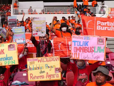 Sejumlah buruh membawa poster saat mengikuti aksi bertajuk May Day Fiesta 2022 di Stadion Gelora Bung Karno (GBK), Senayan, Jakarta Pusat, Sabtu (14/5/2022). Dalam aksi kali ini, massa buruh membawa 18 tuntutan, di antaranya menolak omnibus law UU Cipta Kerja, wujudkan kedaulatan pangan dan dan menolak kenaikan Pajak Pertambahan Nilai (PPN). (Liputan6.com/Angga Yuniar)