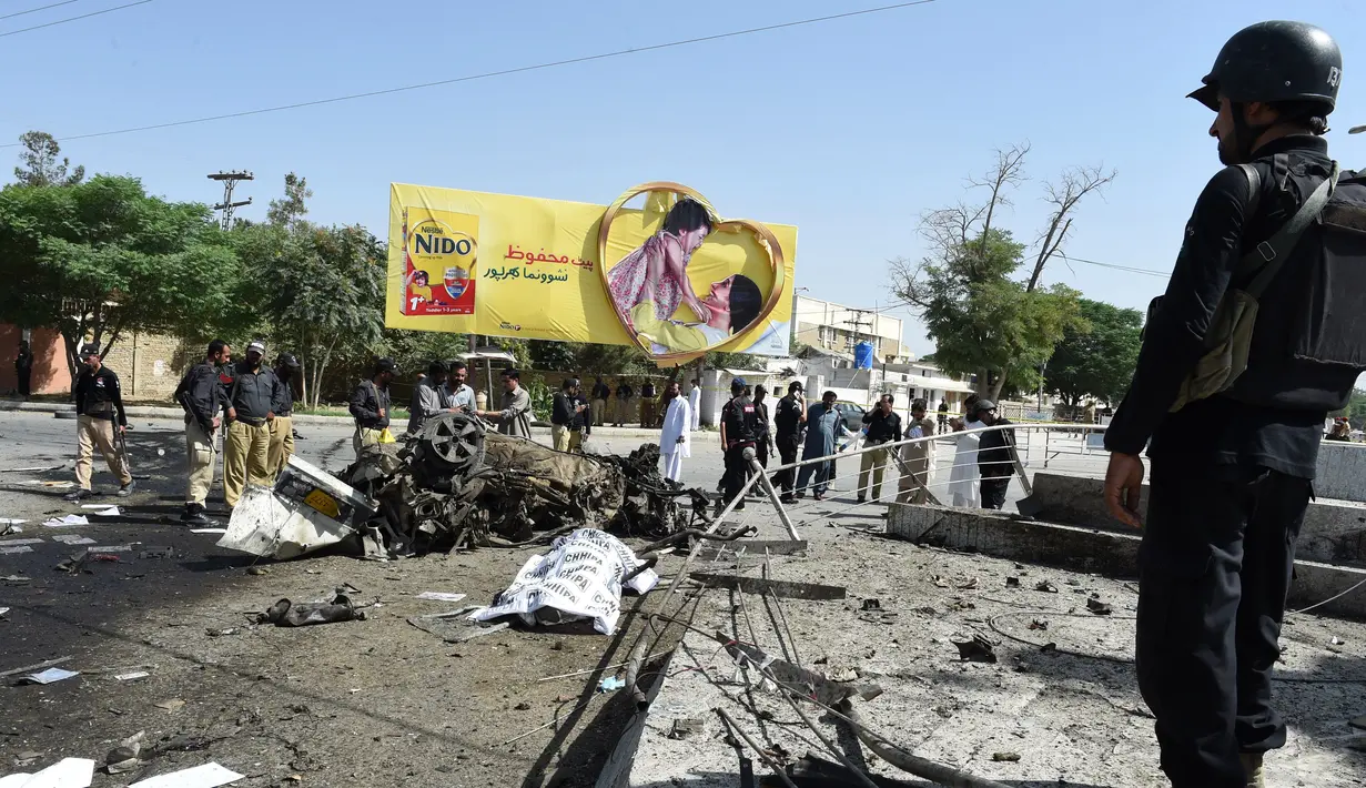 Salah satu mayat tergeletak di lokasi ledakan bom mobil di dekat kantor kepala kepolisian kota Quetta, bagian barat-daya Pakistan, Jumat (23/5). Pasukan keamanan dan polisi telah menutup lokasi ledakan dan daerah sekitarnya. (BANARAS KHAN/AFP)