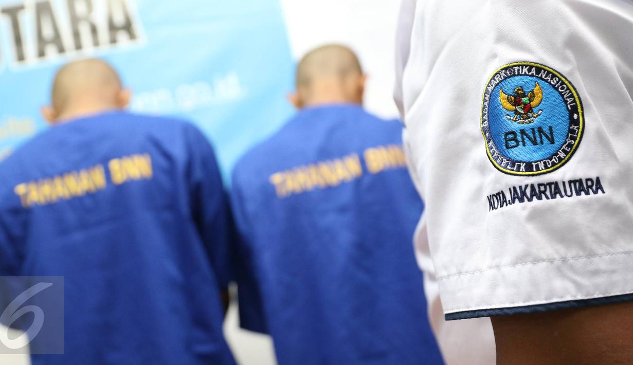 Petugas BNN menunjukkan dua tersangka berinisial H dan TS di kantor BNN Kota Jakarta Utara, Selasa (15/11). BNN Kota Jakarta Utara berhasil mengamankan barang bukti berupa sabu seberat 15,12 gram serta 50 butir ekstasi. (Liputan6.com/Immanuel Antonius)