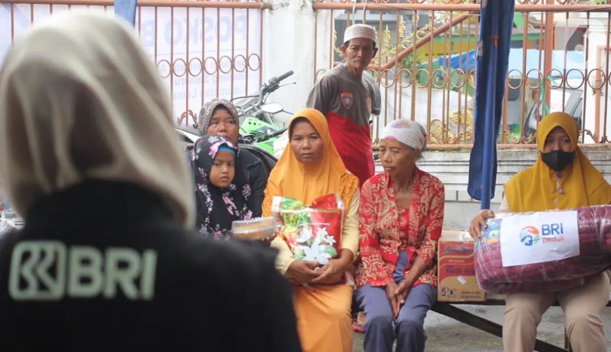 Warga terdampak erupsi Gunung Semeru saat menerima bantuan dari BRI melalui CSR BRI Peduli di posko BRI Peduli Bencana Semeru Desa Penanggal, Lumajang (06/12/2021). BRI juga menyediakan 12 mobil untuk bantuan evakuasi sekaligus membawa barang-barang kebutuhan warga. (Liputan6.com/HO/Humas BRI)