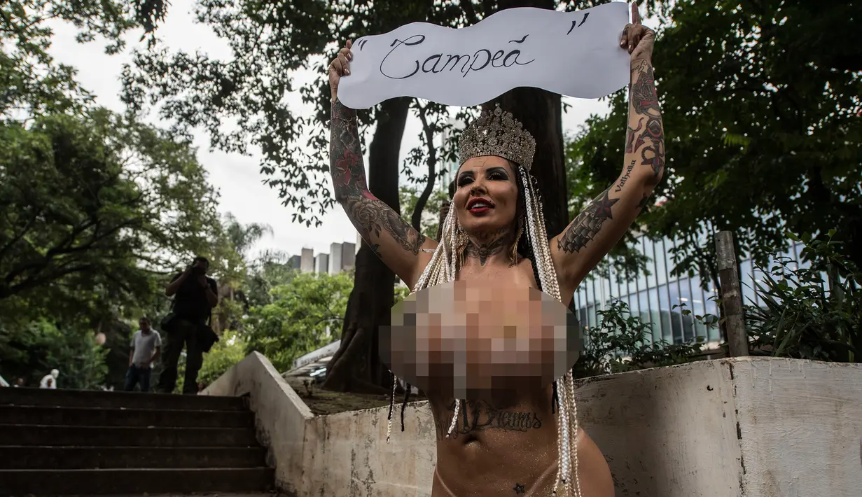Penari Samba, Sabrina Boing Boing dari sekolah Samba Tautape berjalan memegang poster bertuliskan "Juara" di Jalan Paulista, Sao Paulo, Brasil (2/3). Aksi Sabrina ini merayakan sekolahnya menang dalam parade karnaval Samba. (AFP Photo / Nelson Almeida) 