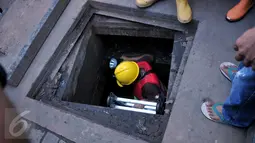 Petugas memasuki gorong-gorong saat olah TKP di Jalan Medan Merdeka Selatan, Jakarta, Sabtu (5/3/2016). Di gorong-gorong tersebut petugas menemukan sisa kulit kabel yang diduga menjadi penyebab banjir. (Liputan6.com/Johan Tallo)