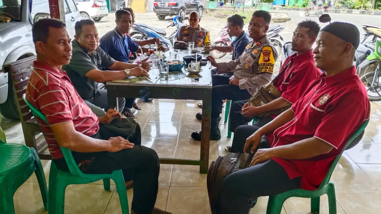 Personel Polres Rokan Hulu berdiskusi dengan simpatisan pasangan calon dan mengajak menjaga keamanan setelah pemungutan suara Pilkada 2024.
