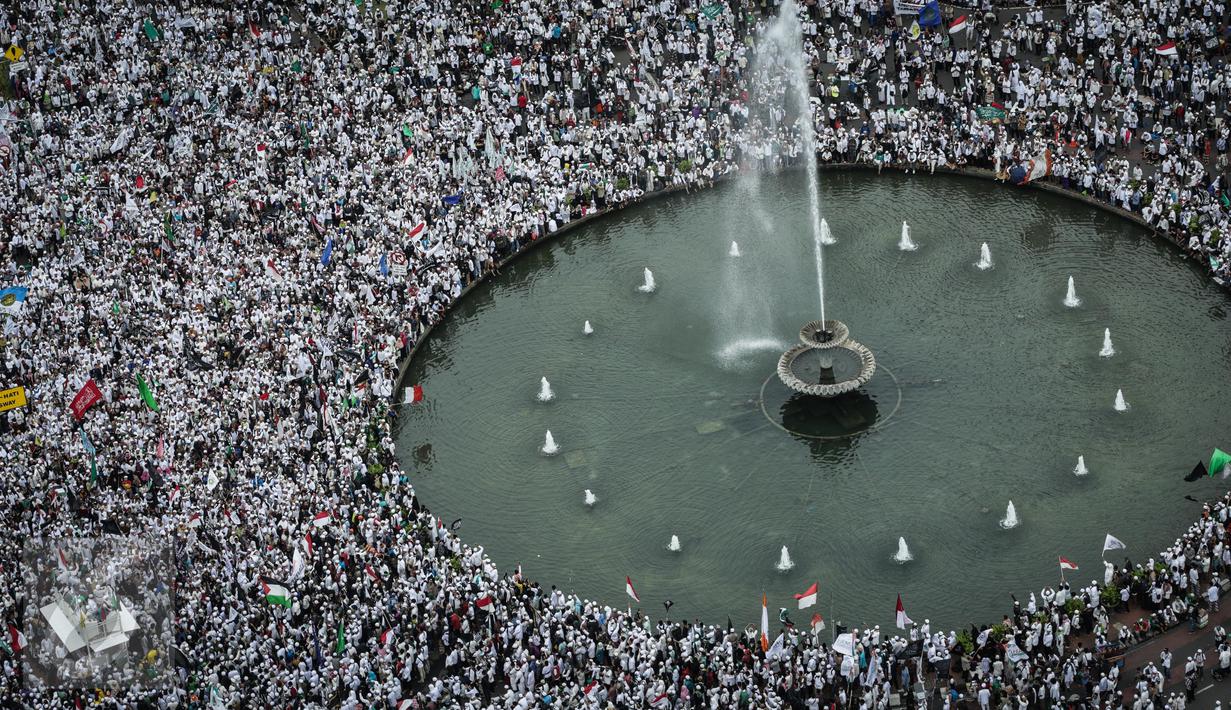 Massa Aksi 31 Maret berkumpul di Bundaran Patung Kuda, Jakarta, Jumat (31/3). Peserta aksi tidak bisa mendekat ke Istana Kepresidenan karena polisi memasang pagar kawat berduri di Jalan Medan Merdeka Barat. (Liputan6.com/Faizal Fanani)