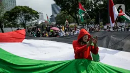 Pengunjuk rasa membentangkan bendera Palestina di depan Kedubes Amerika Serikat, Jumat (21/5/2021). Aksi yang diikuti berbagai elemen masyarakat dan ormas itu mengutuk serangan Israel dan mengajak masyarakat Indonesia untuk mendukung dan membantu Palestina. (Liputan6.com/Faizal Fanani)