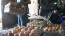Pekerja mengankat peti telur ayam diagen, Jakarta, Senin (27/3). Pemerintah dinilai lamban mengatasi kondisi kelebihan pasokan ayam hidup dan telur, menyebabkan harga jatuh di tingkat peternak. (Liputan6.com/Angga Yuniar)