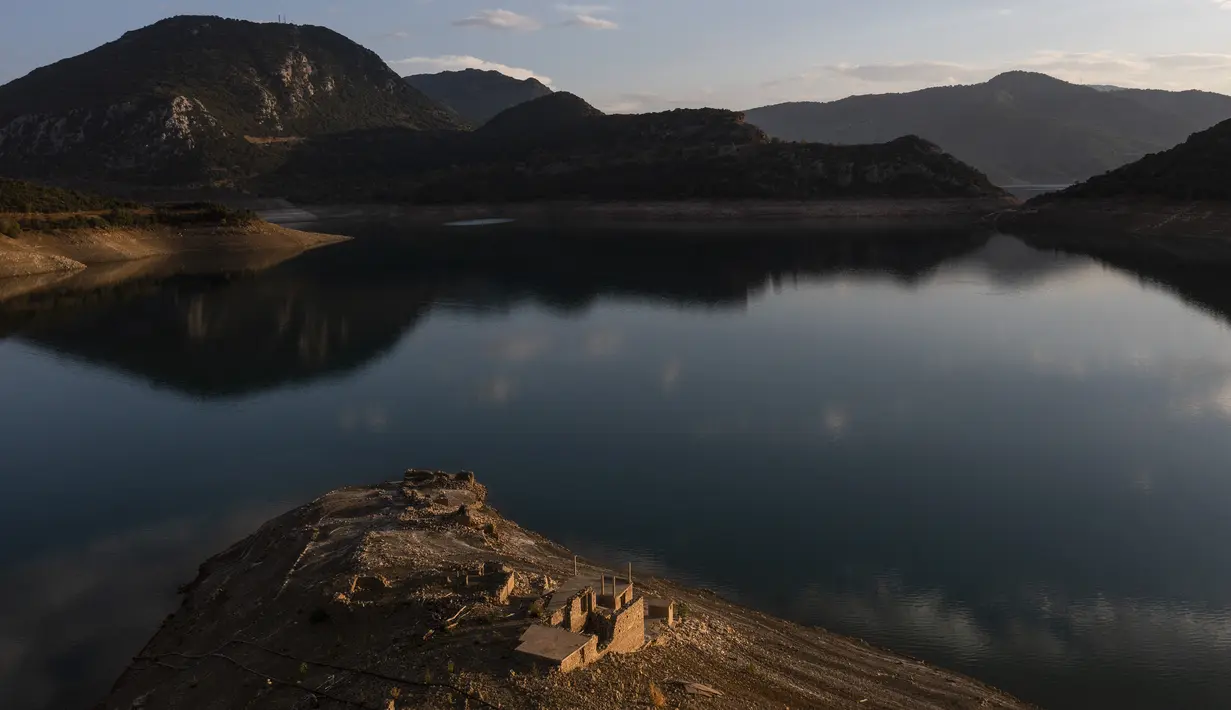Reruntuhan desa Kallio muncul kembali dari Danau buatan Mornos, sebuah waduk di Yunani, akibat suhu yang memecahkan rekor dan kekeringan berkepanjangan di wilayah tersebut. (Angelos TZORTZINIS / AFP)