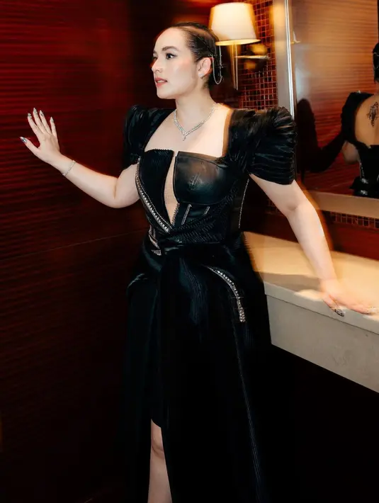 Gaun hitam ini memiliki tekstur pleated yang mendominasi keseluruhan gaun kulitnya [@chelseaislan]