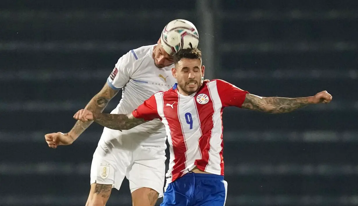 Pemain Paraguay Antonio Sanabria (depan) berebut bola udara dengan pemain Uruguay Jose Gimenez pada pertandingan sepak bola kualifikasi Piala Dunia 2022 di Stadion General Pablo Rojas, Asuncion, Paraguay, 27 Januari 2022. Uruguay menang 1-0. (AP Photo/Jorge Saenz)
