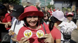 Pendukung Basuki Tjahaja Purnama atau Ahok menunjukkan pin "Pembela Pancasila" saat kembali menggelar aksi di depan Pengadilan Tinggi DKI Jakarta, Jumat (12/5). Massa menuntut agar penangguhan penahanan Ahok dikabulkan. (Liputan6.com/Faizal Fanani)