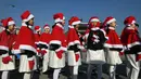 Anak-anak Korea Selatan mengenakan pakaian Santa Claus berjalan di depan Istana Gyeongbokgung, Seoul, Jumat (30/11). The Salvation Army meluncurkan kampanye amal akhir tahun untuk orang miskin. (Jung Yeon-je/AFP)