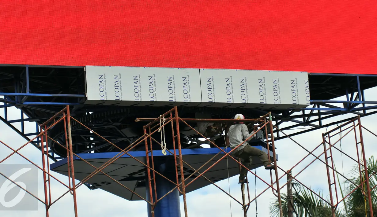 Pekerja saat memasang billboard LED di kawasan Senayan, Jakarta, Selasa (29/12). Penggantian ini bertujuan untuk memperindah kota dan meningkatkan pendapatan asli daerah (PAD). (Liputan6.com/Yoppy Renato)