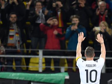 Gelandang Jerman, Lukas Podolski, melambaikan tangan ke suporter usai laga persahabatan kontra Inggris di Stadion Signal Iduna Park, Jerman, Rabu, (22/03/2017). Pertandingan tersebut adalah laga terakhir Podolski bersama Jerman. (AFP/ Marius Becker)