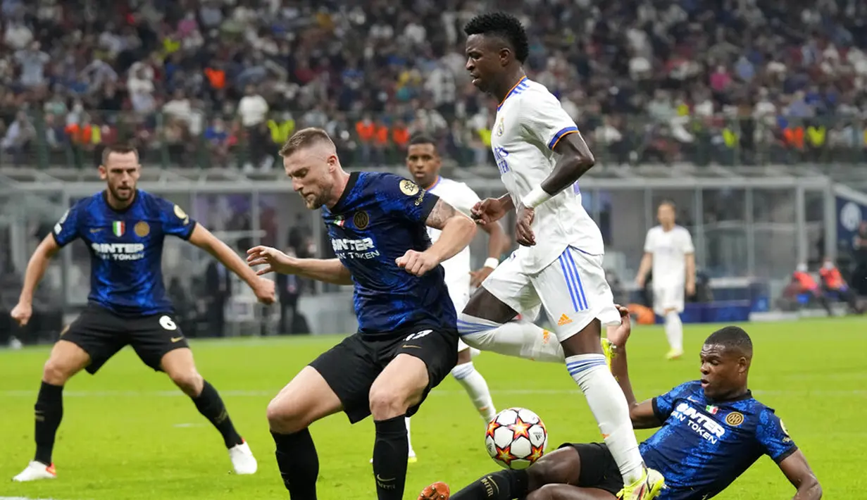 Pemain Real Madrid Vinicius Junior (tengah) bersaing memperebutkan bola dengan pemain Inter Milan Milan Skriniar (kiri) dan Denzel Dumfries (kanan) pada pertandingan Grup D Liga Champions di Stadion San Siro, Milan, Italia, Rabu (15/9/2021). Real Madrid menang 1-0. (AP Photo/Antonio Calanni)