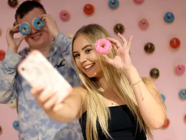 Pengunjung berswafoto ketika mengunjungi The Selfie Factory di pusat perbelanjaan Westfield, London pada 11 September 2019. Dengan membayar 10 poundsterling, pengunjung bisa berfoto di ruangan yang berlatar unik dan menggemaskan. (Isabel INFANTES / AFP)