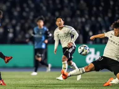 Pemain Kawasaki Frontale, Taisei Miyashiro (kiri), menendang bola ke gawang Yokohama F. Marino dalam pertandingan J-League dalam pertandingan yang berlangsung di Todoroki Stadium, Kawasaki, Jumat (17/2/2023). Musim Ini Taisei Miyashiro memimpin lini depan Kawasaki Frontale dengan delapan gol. (AFP/Yuichi Yamazaki)