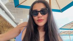 Menikmati waktu santainya, Aaliyah yang cantik mengenakan tanktop biru ini semakin elegan dengan kacamata hitam serta rambut panjangnya yang terurai. (Liputan6.com/IG/@aaliyah.massaid)