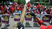 Massa membawa berbagai atribut saat aksi long march menuju Istana Presiden, Jakarta, Selasa (8/3). Aksi memperingati Hari Perempuan Internasional ini menuntut pemerintah menegakkan keadilan terhadap perempuan Indonesia. (Liputan6.com/Gempur M Surya)