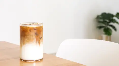 Segarnya es kopi karamel dengan topping krim kocok dan sirup karamel, sempurna untuk dinikmati di hari yang panas