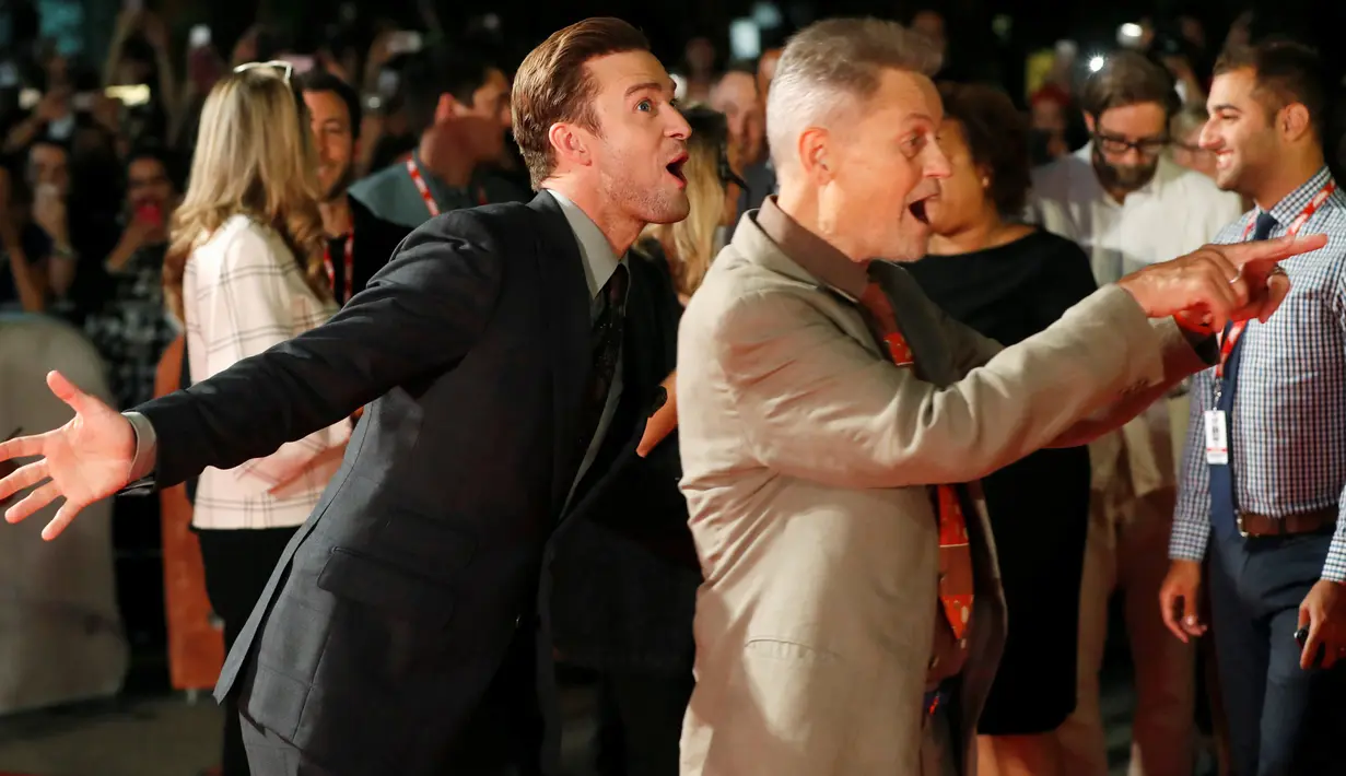 Aksi konyol penyanyi Justin Timberlake dibelakang sutradara Jonathan Demme setibanya di karpet merah film "Justin Timberlake and the Tennessee Kids" pada Toronto International Film Festival (TIFF) ke-41, di Kanada, Selasa (13/9). (REUTERS/Mark Blinch)