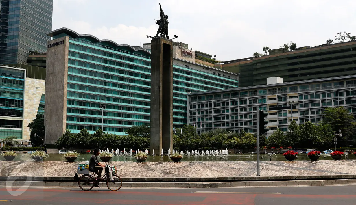 Seorang pedagang tampak melintasi kawasan Bundaran HI, Jakarta, Selasa (1/9/2015). Arus lalu lintas di kawasan Bundaran HI terlihat sepi dari pedemo. (Liputan6.com/Yoppy Renato)