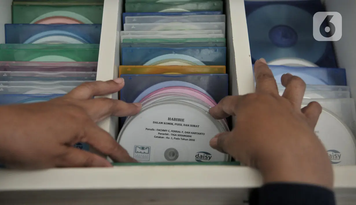 Pustakawan saat memilih buku audio digital berbentuk CD di Perpustakaan Mitra Netra, Jakarta, Selasa (3/12/2019). Adanya perpustakaan ini diharapkan para disabilitas dapat menempuh pendidikan mandiri, berkualitas, dan terwujudnya kehidupan tunanetra yang bermakna dalam masyarakat inklusif. (merdeka.