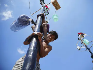 Seorang peserta saat mengikuti lomba panjat pinang kolosal yang diadakan untuk merayakan HUT ke-80 Kemerdekaan Indonesia, di Pantai Ancol, Jakarta, Minggu 17 Agustus 2025. (AP Photo/Tatan Syuflana)
