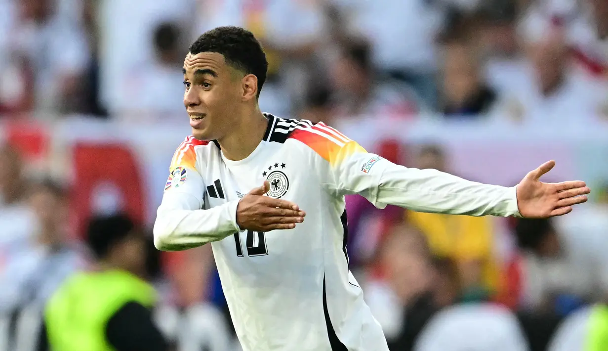 Gelandang Jerman, Jamal Musiala memberi isyarat selama pertandingan perempat final Euro 2024 melawan Spanyol di Stuttgart Arena di Stuttgart pada 5 Juli 2024. Jamal Musiala berhasil mencatatkan namanya dalam deretan pencetak gol terbanyak di Euro 2024 dengan tiga gol. (Tobias SCHWARZ/AFP)