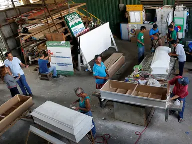 Para mantan pengguna narkoba membuat peti mati di kota Olongapo, Filipina utara, (5/10). Kegiatan ini merupakan bagian dari program rehabilitasi pemerintah setempat bagi mereka yang terjerumus dalam penyalahgunaan narkoba. (REUTERS/Erik De Castro)