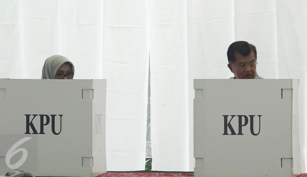 Wakil Presiden Jusuf Kalla (JK) bersama istri, Mufidah Kalla, melakukan pencoblosan di TPS 03 Kelurahan Pulo, Jakarta Selatan, Rabu (19/4). Di TPS bernuansa Betawi itu, JK memberikan suaranya pada Pilkada DKI putaran kedua. (Liputan6.com/Herman Zakharia)