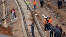 Aparat kepolisian berdiri dekat sebuah kereta api yang keluar jalur dan terguling di Sidi Bouknadel dekat ibu kota Rabat, Maroko, Selasa (16/10). Pihak berwenang Maroko menyatakan mereka sedang menyelidiki penyebab kecelakaan. (AP/Abdeljalil Bounhar)