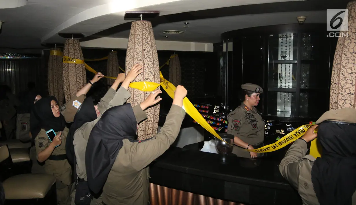 Petugas Satpol PP menyegel Sense Karaoke di Mangga Dua Square, Jakarta, Kamis (19/4). Menurut sekuriti setempat, Sense Karaoke sudah tidak beroperasi lagi sejak BNN melakukan razia pada Rabu (11/4) malam. (Liputan6.com/Arya Manggala)
