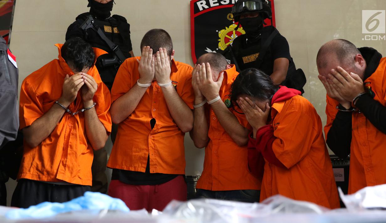 Lima tersangka pembobol uang dari mesin ATM dengan teknik skimming diperlihatkan petugas Resmob Polda Metro Jaya saat rilis di Jakarta, Sabtu (17/3). Sindikat ini membobol 64 bank pada sejumlah negara. (Liputan6.com/Helmi Fithriansyah)