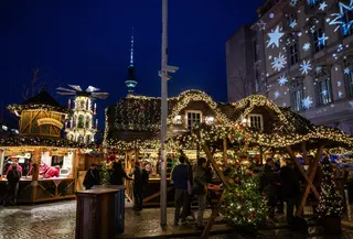 Pengunjung memadati stan di pasar Natal di Forum Humboldt Berlin, dengan Menara TV terlihat di latar belakang pada tanggal 19 Desember 2024 di Berlin, Jerman, selama musim liburan.John MACDOUGALL / AFP