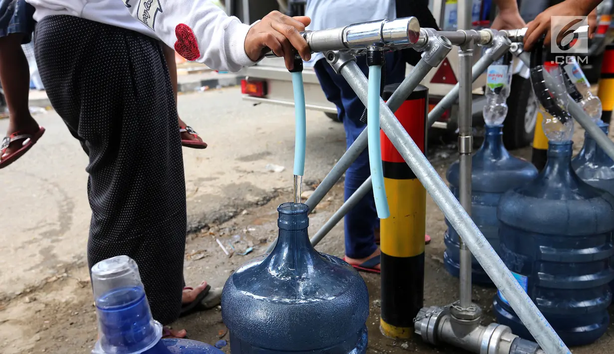 Pengungsi korban gempa dan tsunami Palu mengambil air di mobil instalasi pengolahan air Kementerian Pekerjaan Umum dan Perumahan Rakyat (PUPR)untuk dikonsumsi di halaman kantor Wali Kota Palu, Sulawesi Tengah, Senin (8/10). (Liputan6.com/Fery Pradolo)