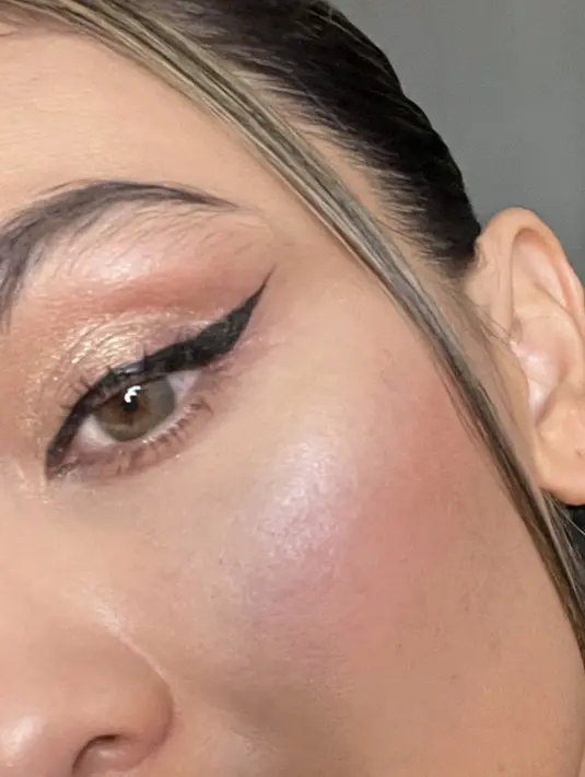 Riasan wajahnya sedikit glamour dengan eyeliner wings dan eyeshadow shimmer